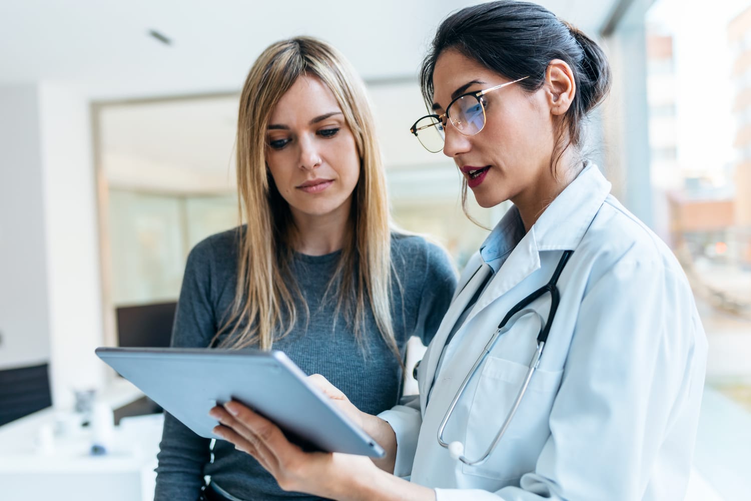 Ärztin erklärt einer Patientin die Behandlung